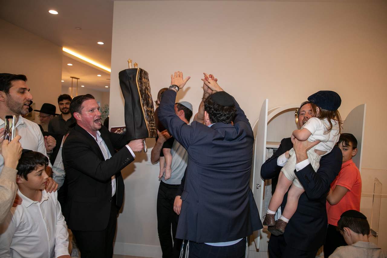 Friends dancing with the Sefer Torah inside