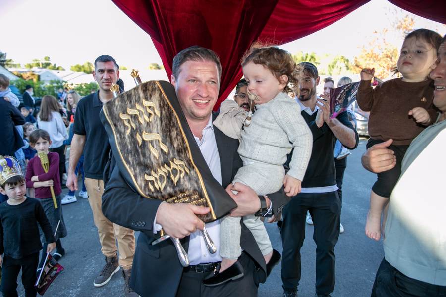 Holding the Torah with a little one in his arm